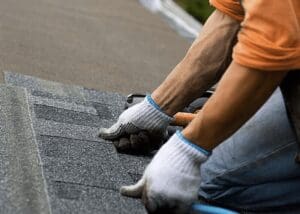 Composite shingles: The image shows a roofer installing the shingles to the roof.